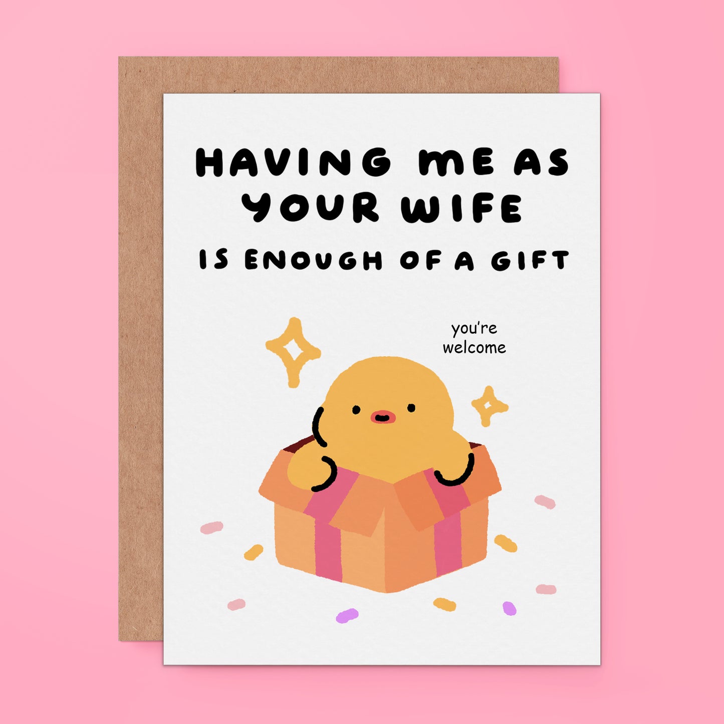 A white greeting card with a brown kraft envelope, featuring a cute cartoon chick popping out of a gift box with the text 'HAVING ME AS YOUR WIFE IS ENOUGH OF A GIFT' and 'you're welcome'.