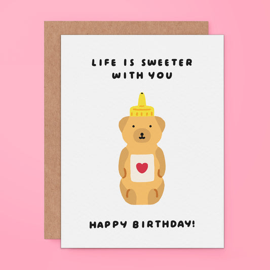 cute pun birthday card featuring a honey bear bottle and text "life is sweeter with you"