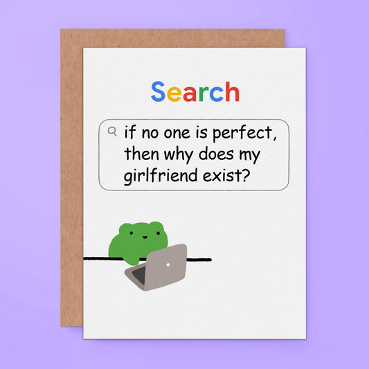 A white greeting card with a brown kraft envelope behind it, featuring the word 'Search' in multicolored letters and a speech bubble with the text, 'if no one is perfect, then why does my girlfriend exist?' Below, a small green frog sits on a laptop. The card is shown on a light purple background.