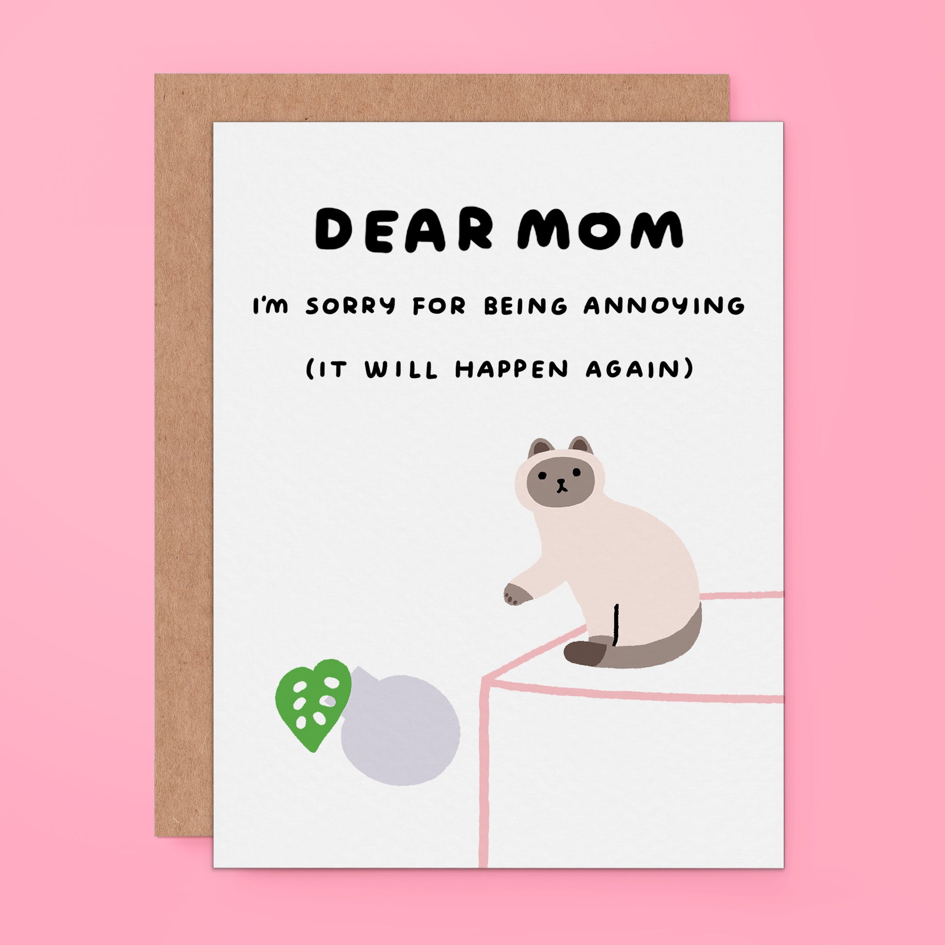 A greeting card with a brown envelope, featuring a white card that reads 'DEAR MOM I'M SORRY FOR BEING ANNOYING (IT WILL HAPPEN AGAIN)' with an illustration of a cat and a green heart on a pink background.